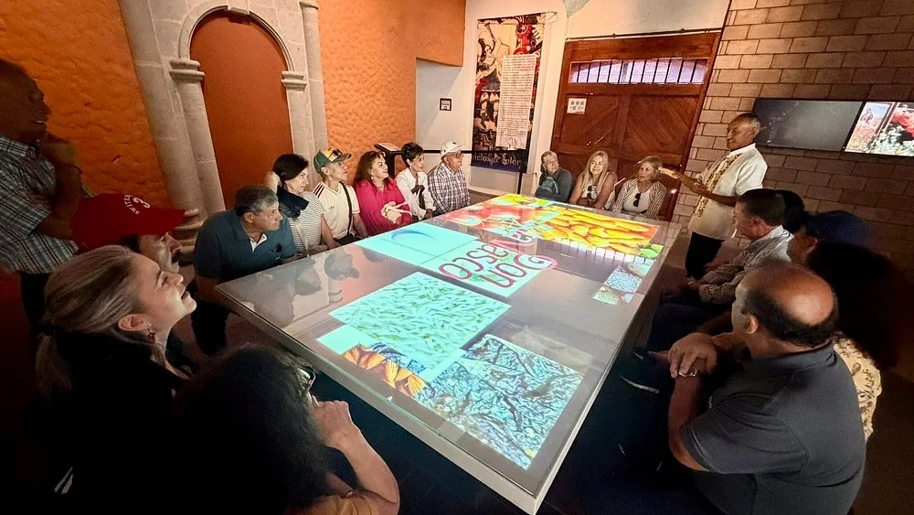 Visitantes utilizando la mesa interactiva del Centro de Interpretación Ruta Don Vasco.