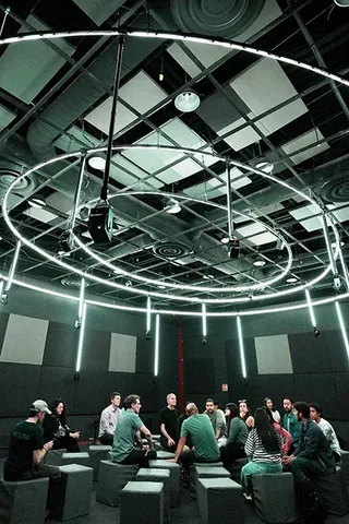 Vista vertical de SONIDARIO con aros, altavoces y público en la sala